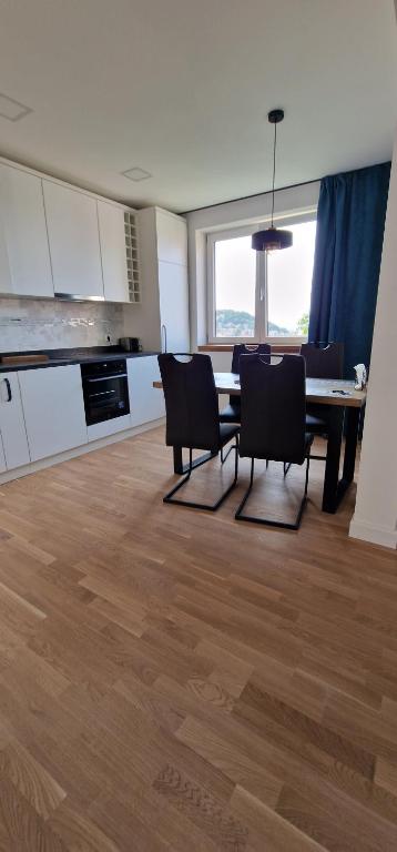 a kitchen and dining room with a table and chairs at Central apartment with city view in Braşov