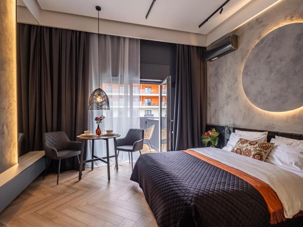 een slaapkamer met een bed en een tafel en stoelen bij Loft House Premium Apartments in Wrocław