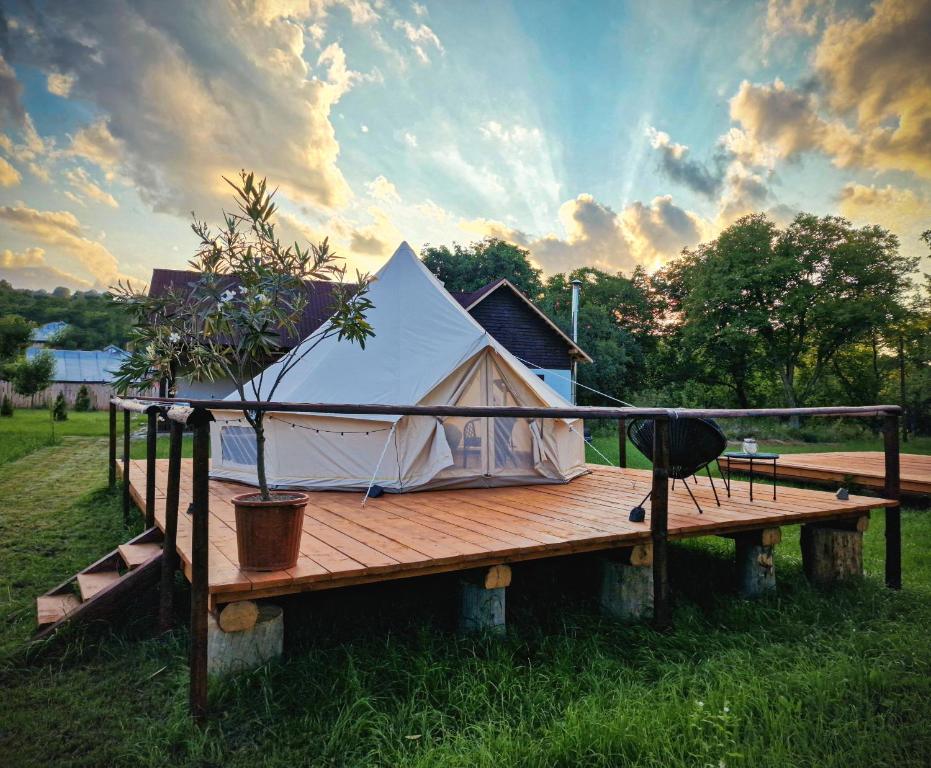 a white tent sitting on a wooden deck at Pensiunea Cocoș 