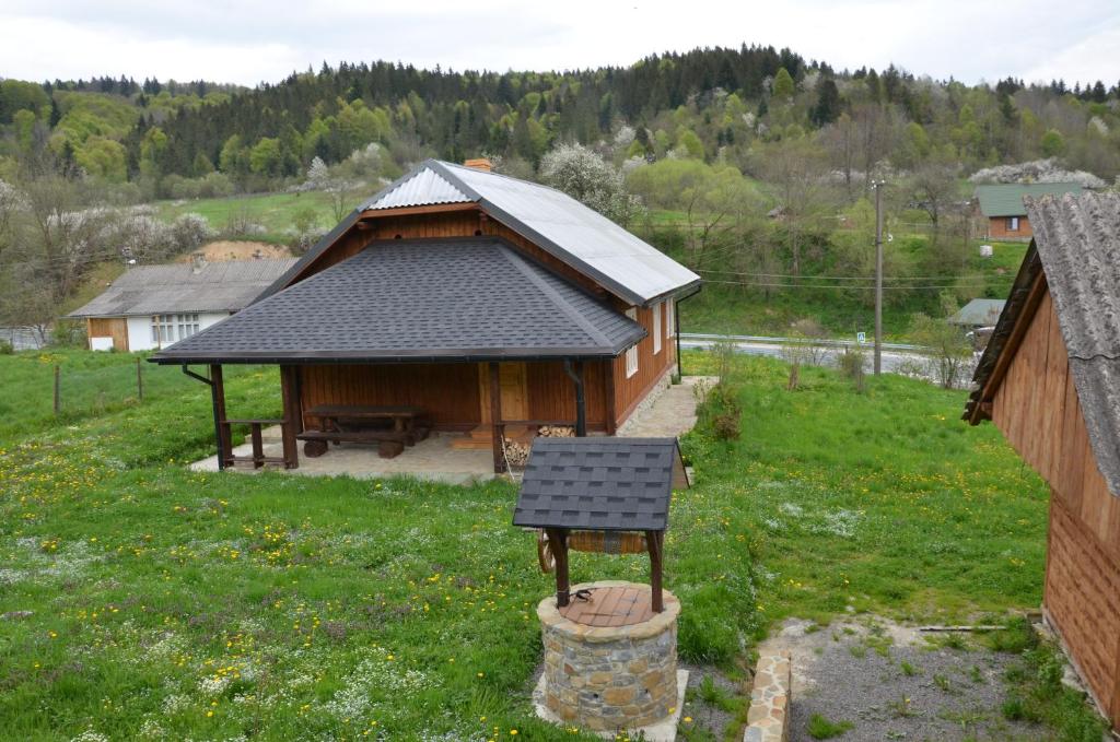 a small building with a table in a field at Вершище in Urych