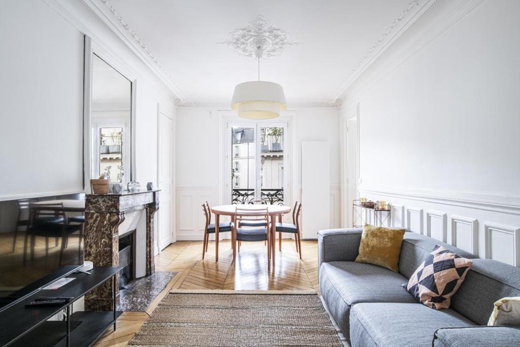 un salon avec un canapé et une table dans l'établissement Pick A Flat's Apartment near Moulin Rouge - Rue Fontaine, à Paris