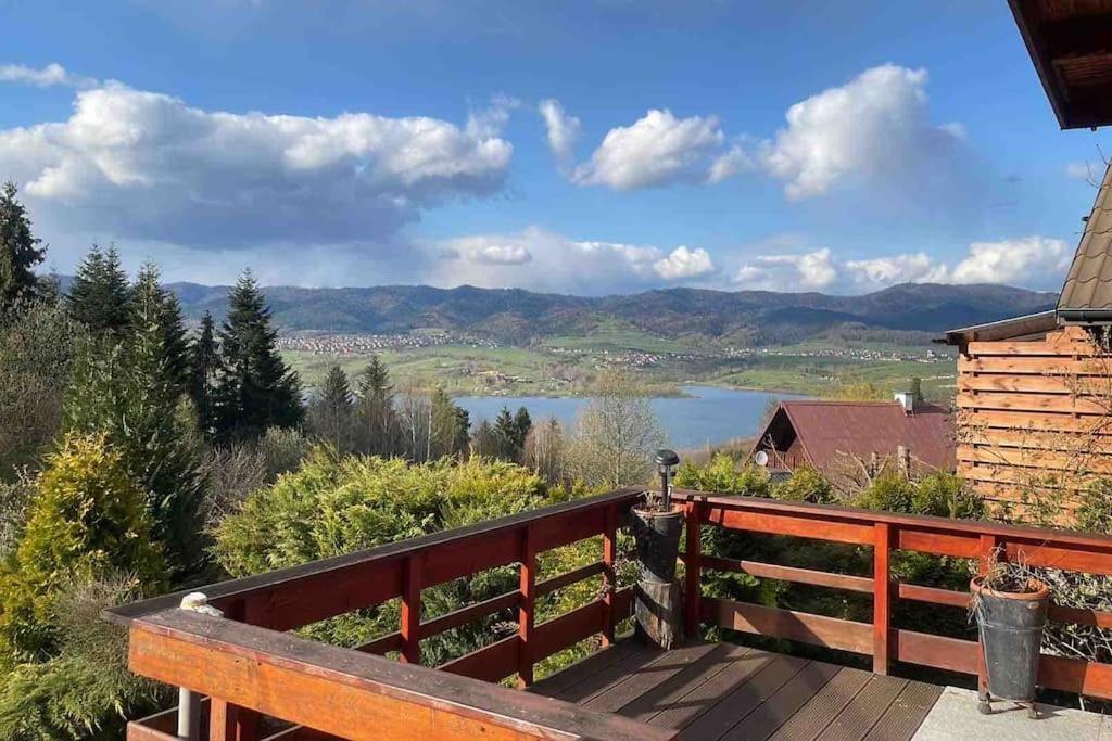 a wooden deck with a view of a lake at Uroczy domek letniskowy. in Falsztyn