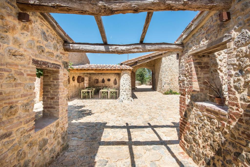 Elle offre une vue sur l'extérieur d'une maison en pierre dotée d'une terrasse. dans l'établissement Agriturismo Casalino18, à Tognazza