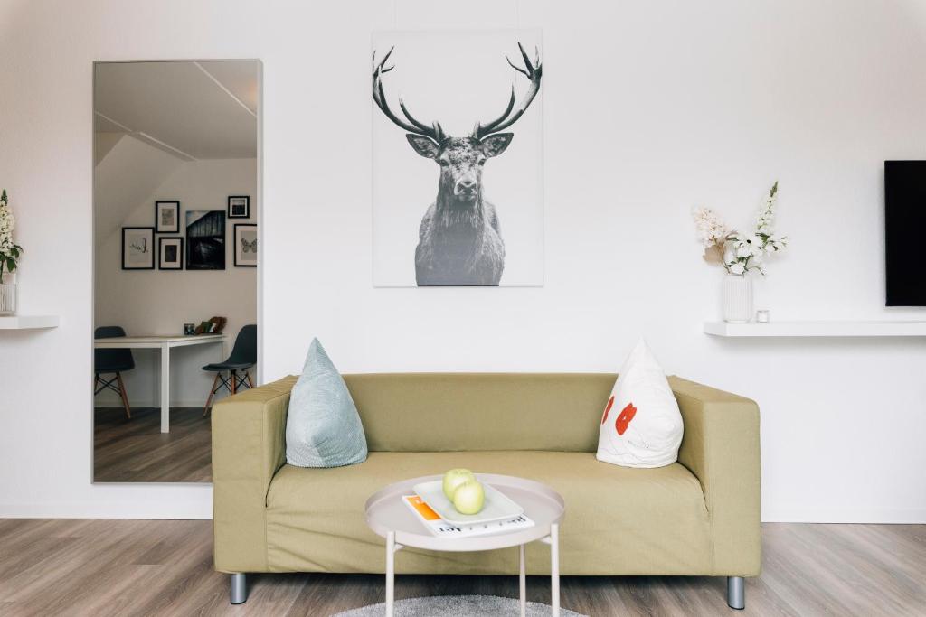 a living room with a couch and a deer on the wall at New Living City Appartement in Bielefeld