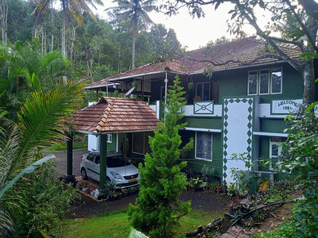 una casa con un coche aparcado delante de ella en Maliyeckal Homestay, en Munnar