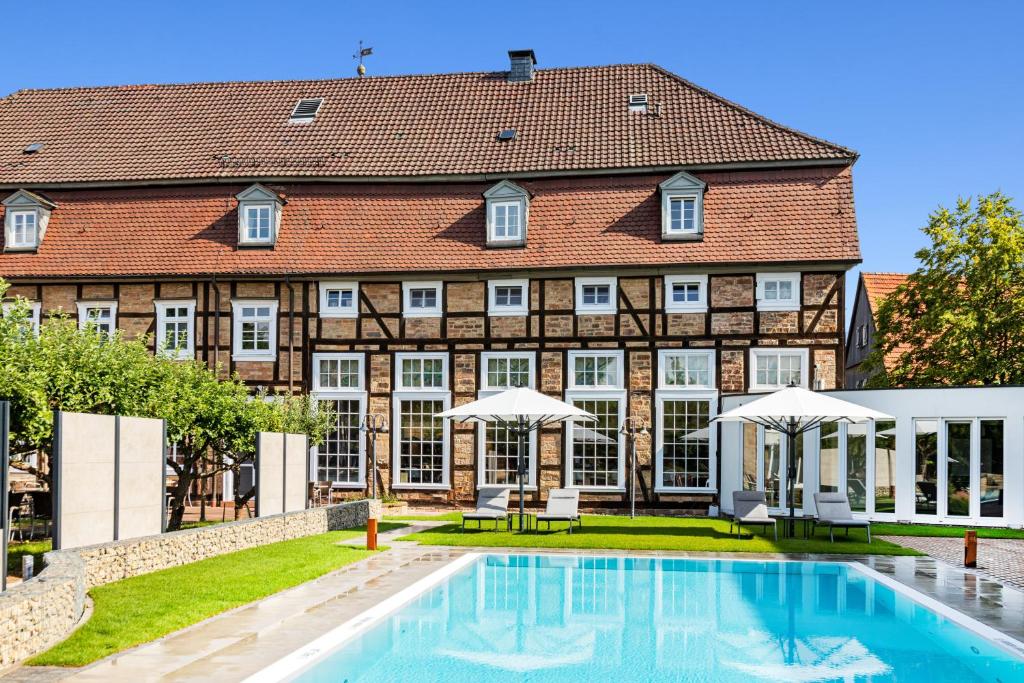 un domaine avec une piscine en face d'un bâtiment dans l'établissement Welcome Hotel Bad Arolsen, à Bad Arolsen