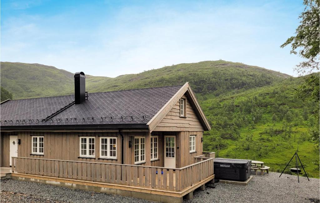 a wooden house with a mountain in the background at Beautiful Home In Norheimsund With Jacuzzi, Wifi And 5 Bedrooms in Norheimsund