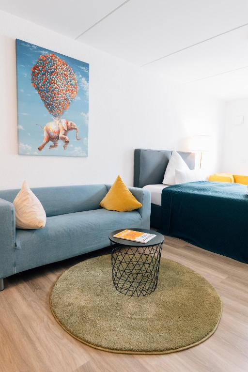 a living room with a blue couch and a table at City - Travel & Living - Appartement in Bielefeld