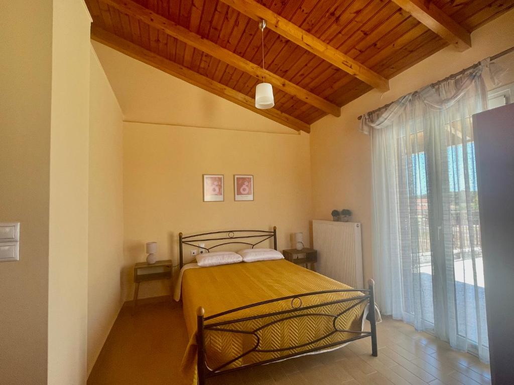 a bedroom with a bed and a large window at Katerina's Apartment in Vonitsa