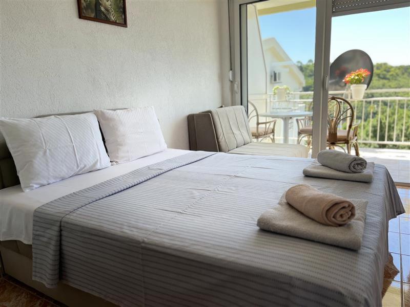 a bedroom with a bed with towels on top of it at Apartmani Neda Bane in Petrovac na Moru