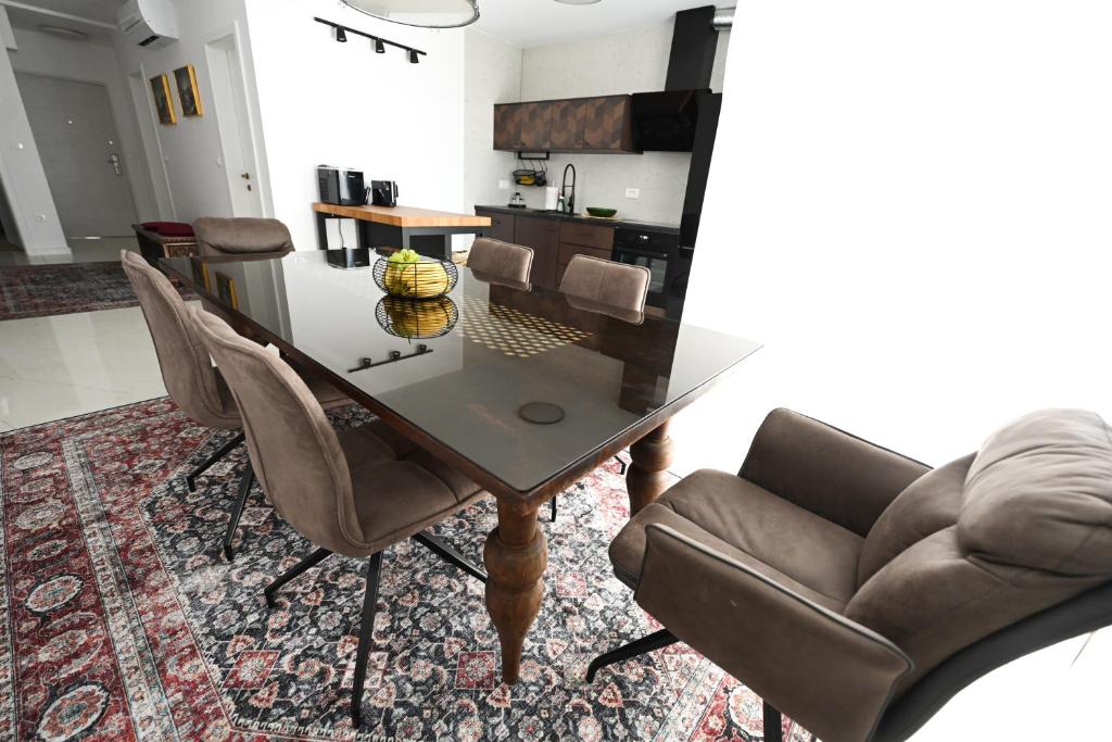 une salle à manger avec une table et des chaises en verre dans l'établissement Apartman Zrno Soli, à Zadar