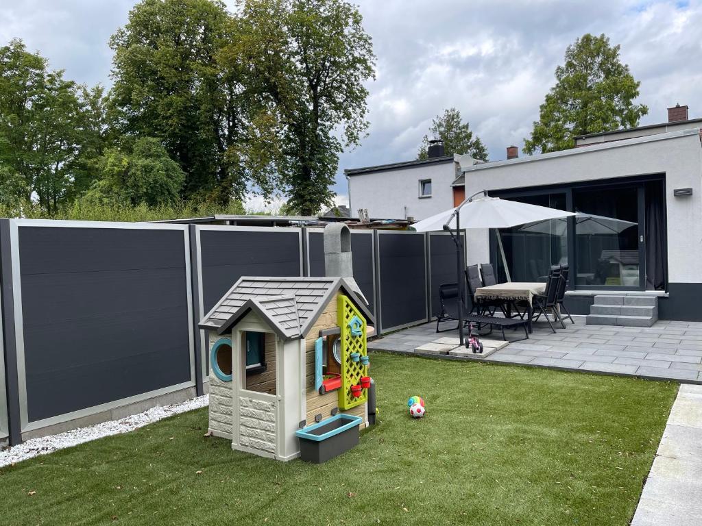 a backyard with a small play house on the grass at Wohnen im Reihenhaus auf Zeit in Lübeck in Lübeck