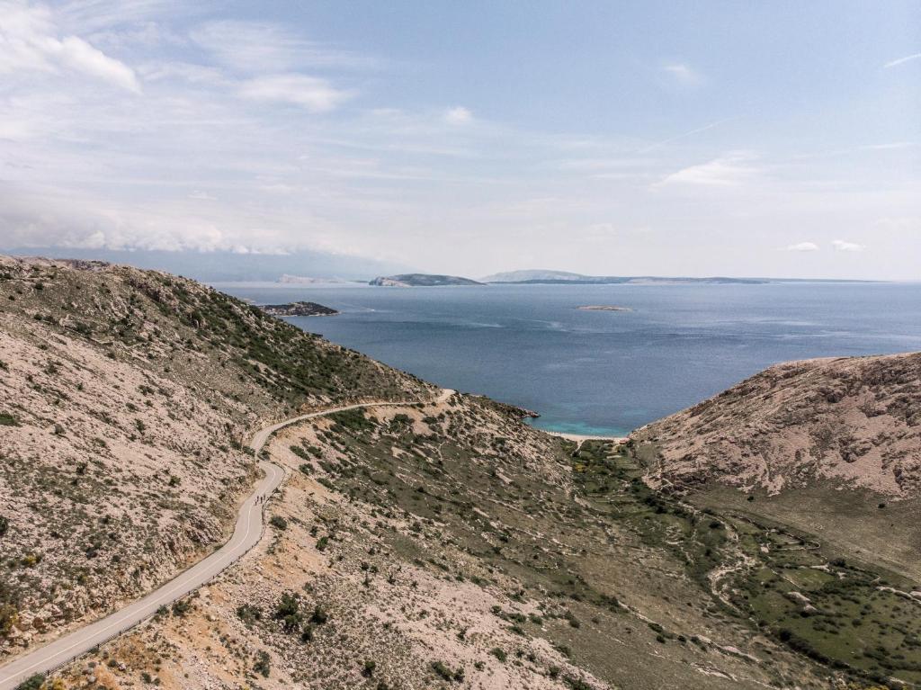 a road on the side of a hill next to the ocean at Falkensteiner Hotel Park Punat in Punat