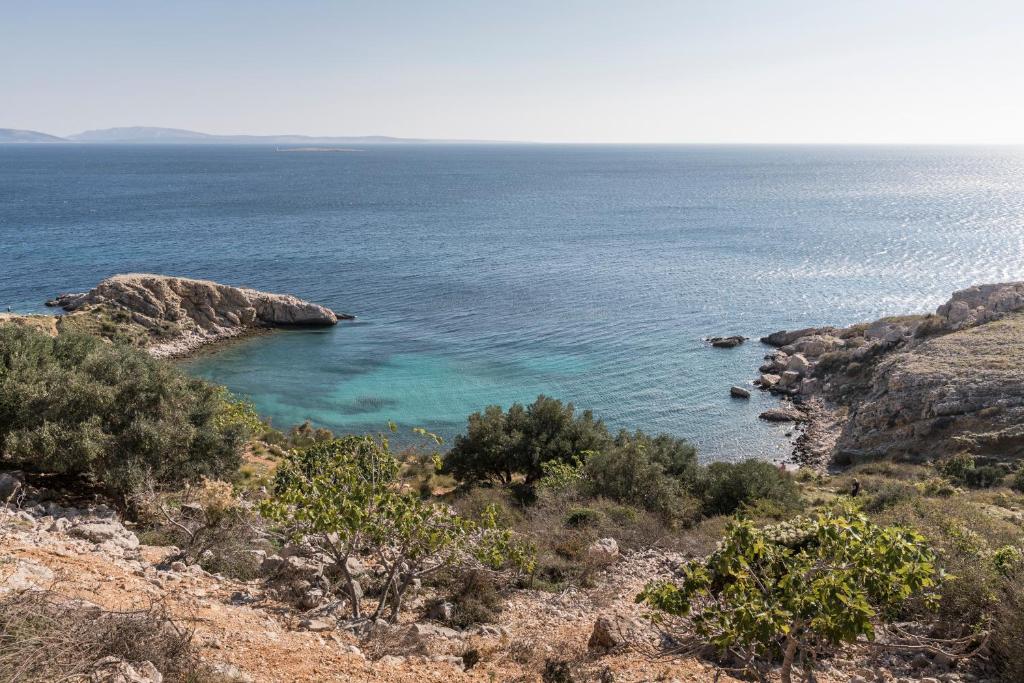 a view of the ocean from a hill with rocks at Falkensteiner Hotel Park Punat in Punat