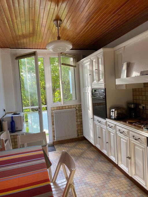 a kitchen with white cabinets and a table and chairs at Appartement lumineux Vue montagne Centre Grenoble in Grenoble
