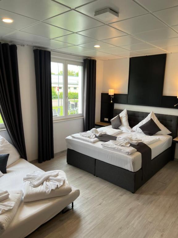 ein Hotelzimmer mit 2 Betten und einem Fenster in der Unterkunft Yebs Hotel in Günzburg