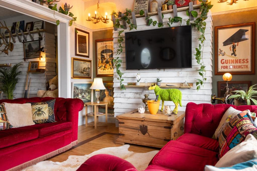 a living room with red couches and a flat screen tv at James' Place at The Park in Merthyr Tydfil