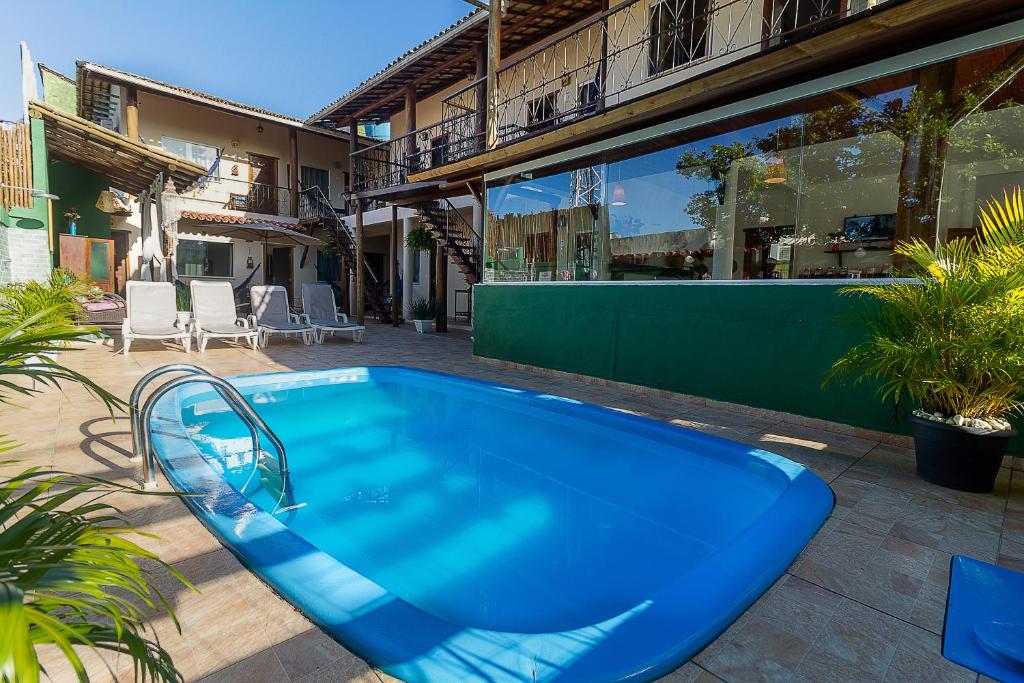 a large blue swimming pool in a courtyard at Pousada Pé na Estrada in Arraial d'Ajuda