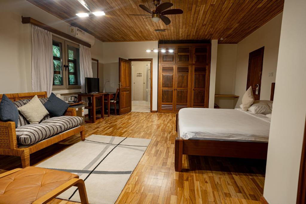 a living room with a bed and a couch at Esther's Hotel in Accra