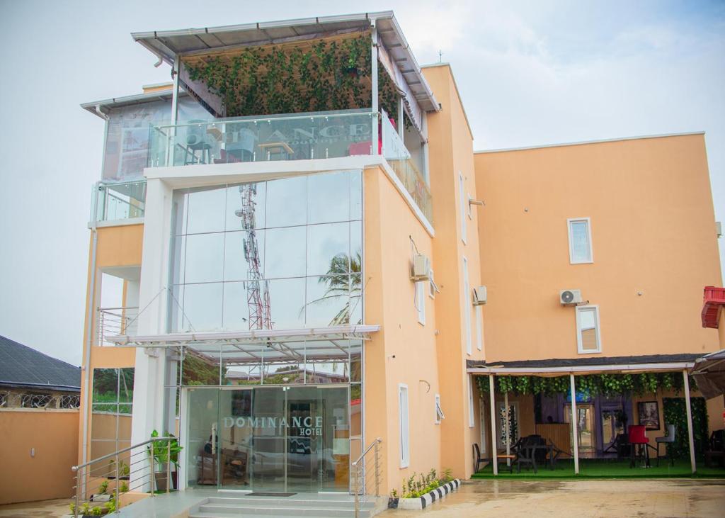 a building with a glass facade with a plant at Dominance Events and Suites in Ibadan