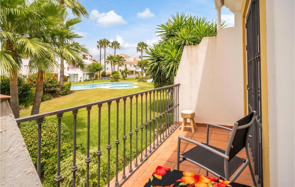 een balkon met een stoel en uitzicht op een zwembad bij Stunning Home In Estepona With Kitchen 