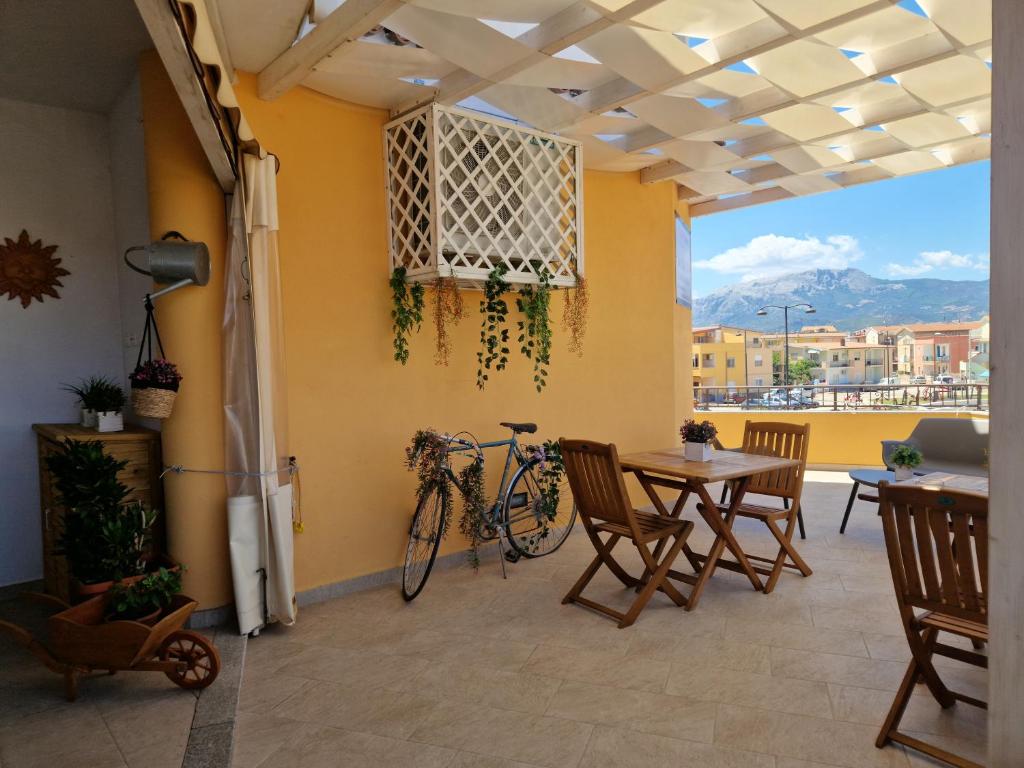 un patio con una mesa y una bicicleta en la pared en Caletta sul Mare en La Caletta