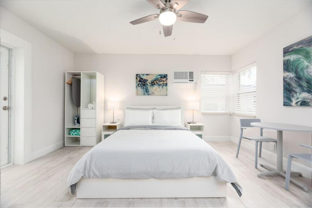 a white bedroom with a bed and a table at Ocean Flats 4 - Lauderdale-by-the-Sea in Fort Lauderdale