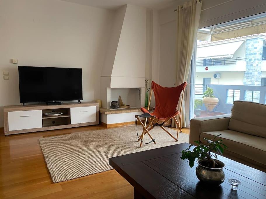a living room with a couch and a tv at Modern Flat in Nafplio in Nafplio