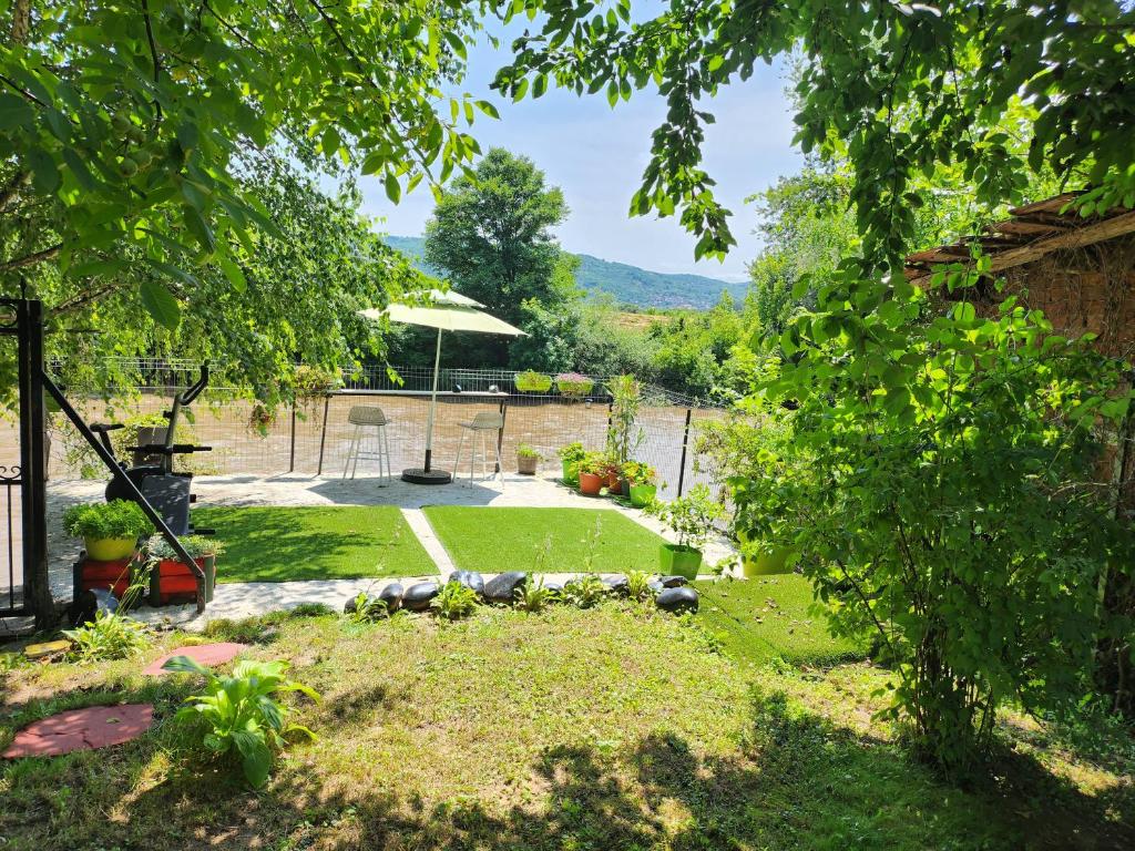ogród ze stołem i parasolem w obiekcie Kuća na obali reke Nišave w mieście Donja Vrežina
