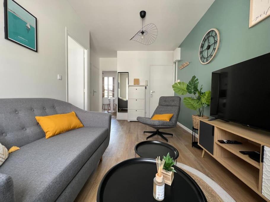 a living room with a couch and a tv at Le Monterelais : Hypercentre in Montereau-Fault-Yonne