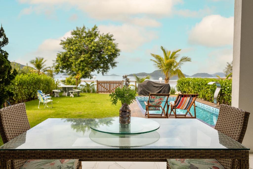 安格拉杜斯雷斯的住宿－Casa Na Praia em Angra dos Reis，一个带桌椅的庭院和一个游泳池