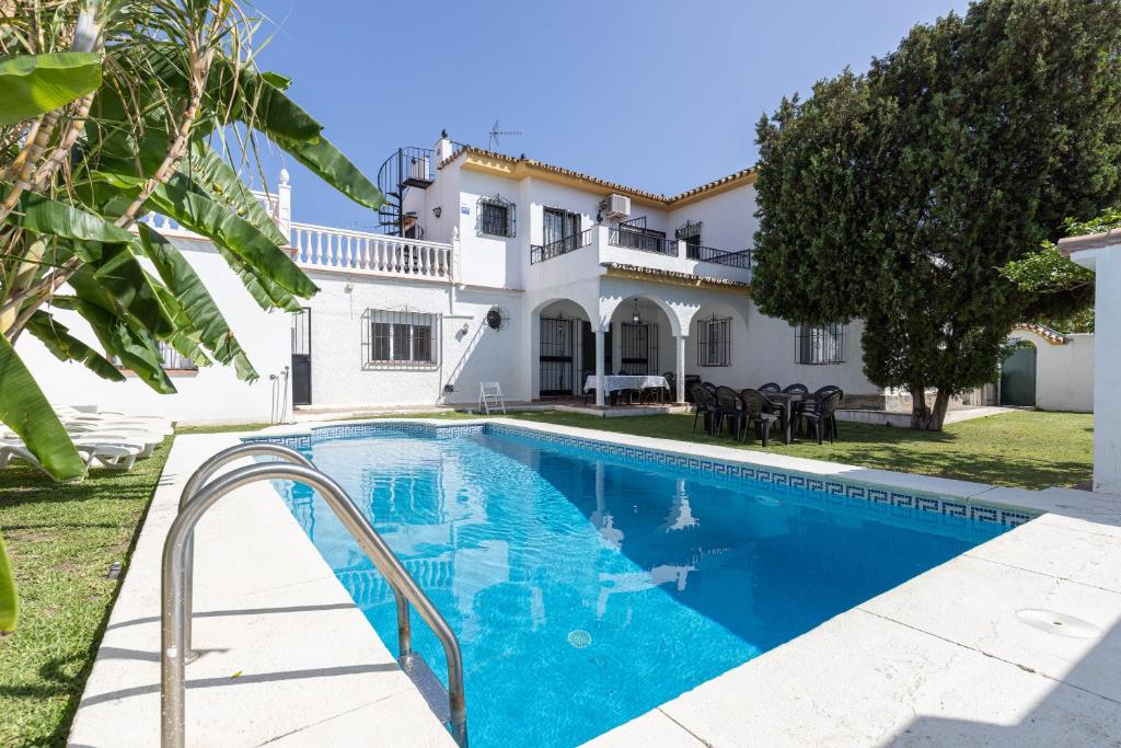 a villa with a swimming pool in front of a house at Casa Yolanda in Marbella