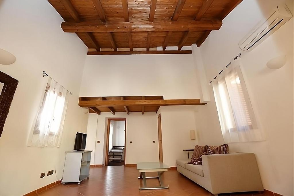 uma sala de estar com um sofá e uma televisão em Aretusa Girgenti Home em Agrigento