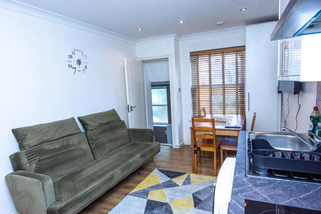 uma sala de estar com um sofá e uma mesa em Evergreen Apartments-Flat 4, London em Londres