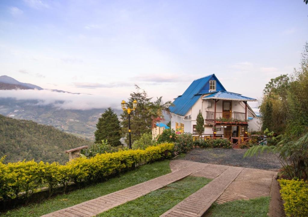 ein Haus mit einem blauen Dach auf einem Hügel in der Unterkunft Finca Villarreal in Cali