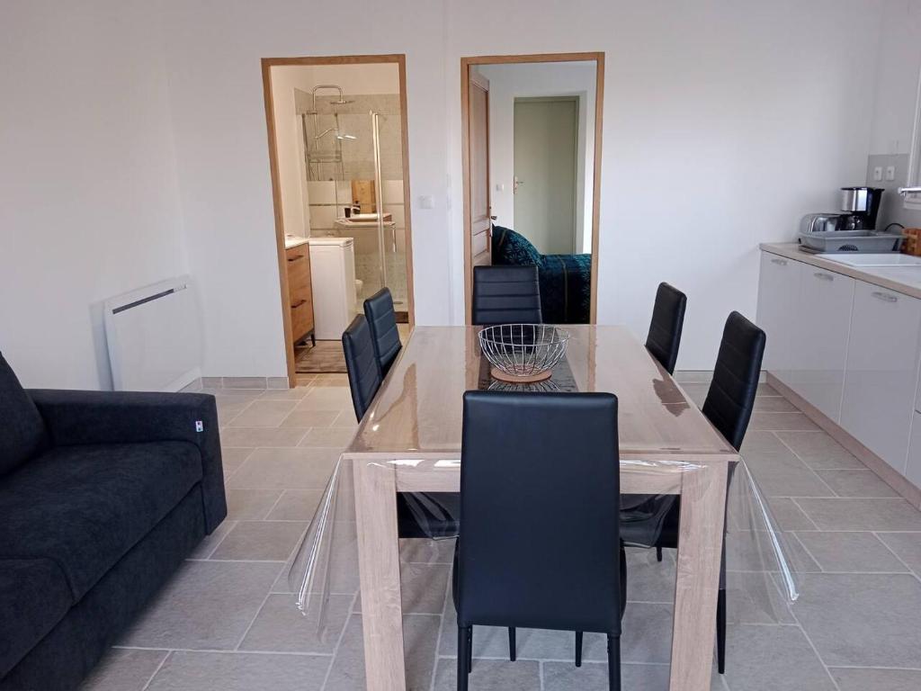 une salle à manger avec une table, des chaises et un canapé dans l'établissement Maison Dominique, à Balzac