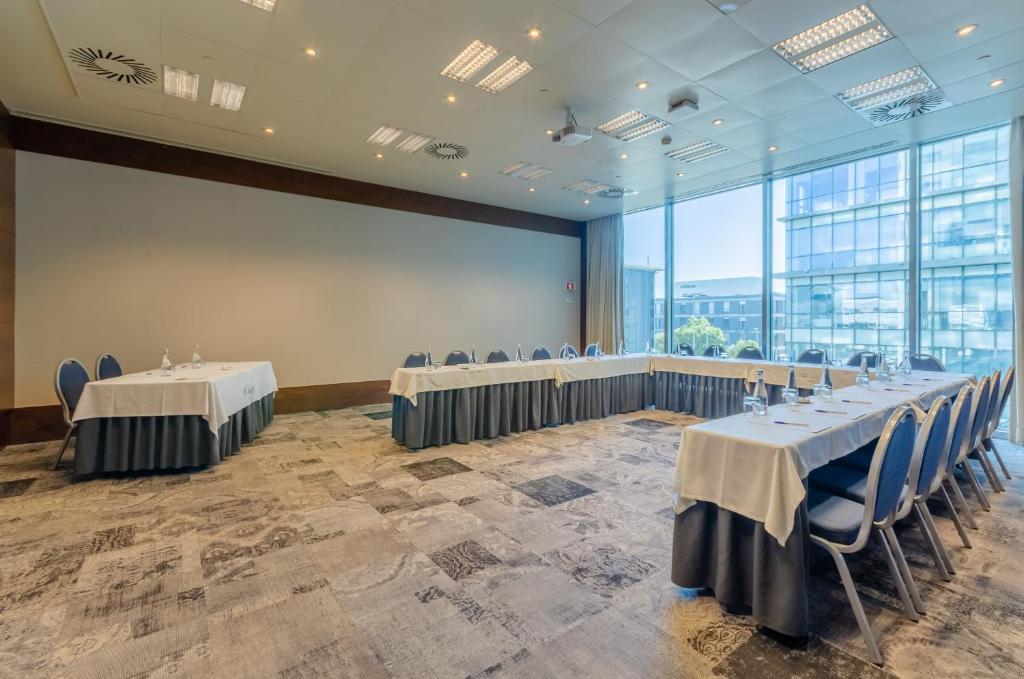 A flexible conference room arranged with perimeter tables and presentation seating.