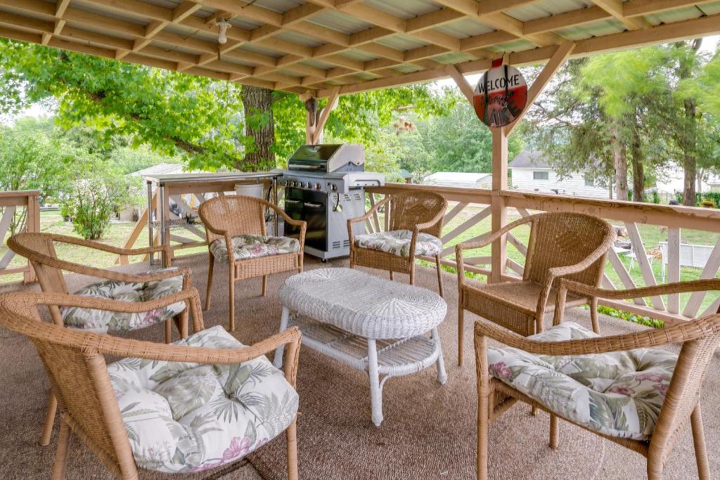 eine Gruppe von Stühlen und Tischen auf einer Terrasse mit einem Grill in der Unterkunft Quaint Warsaw Getaway with Covered Porch and Kayaks! in Warsaw