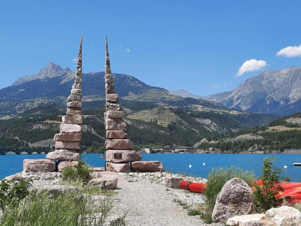 un groupe de tours de pierre à côté d'un plan d'eau dans l'établissement Cocoon Savines, à Savines