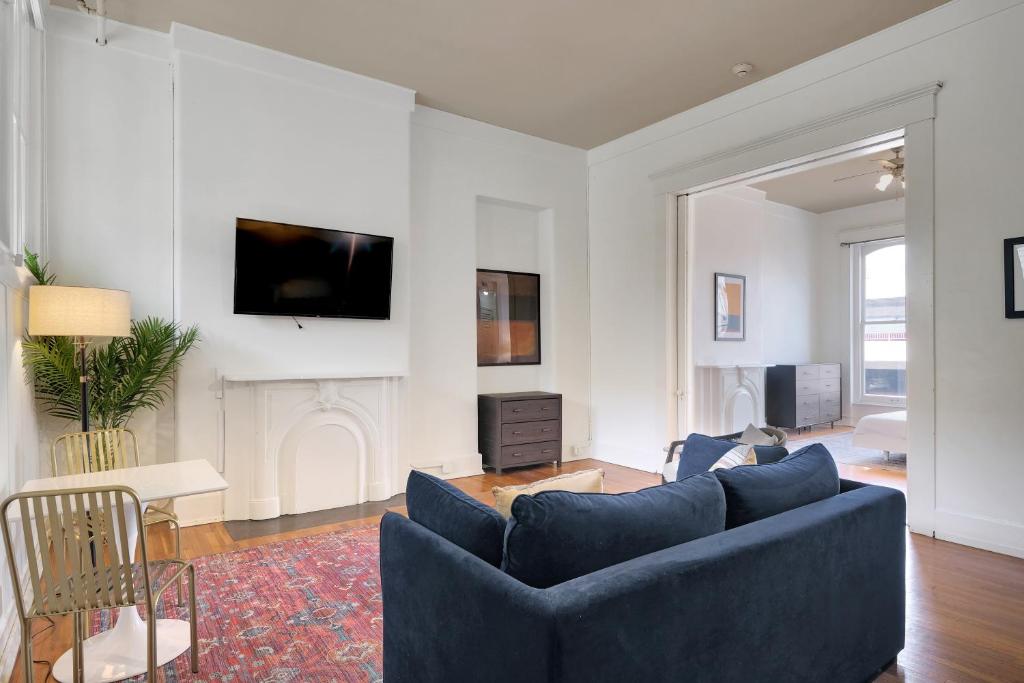 a living room with a blue couch and a fireplace at Historic Charm In Guthrie Coke Lofts in Louisville