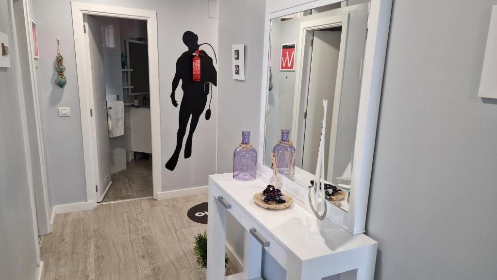 a bathroom with a wall mural of a surfer at Crepúsculo in Puerto de la Madera