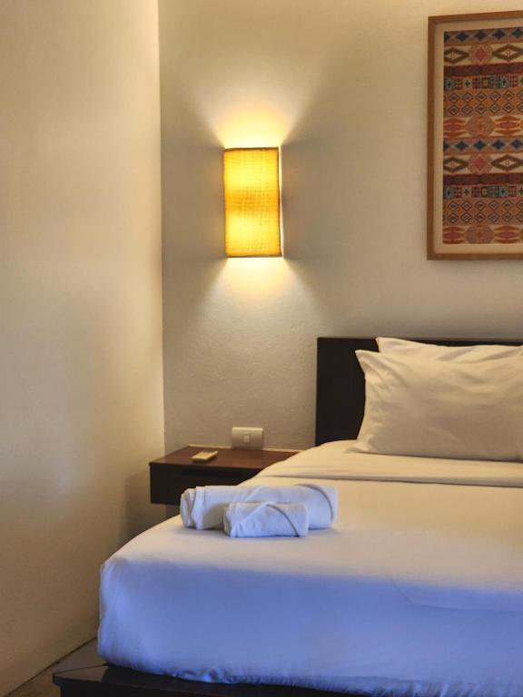 A close view shows the corner of a double bed beside a lit bedside table.