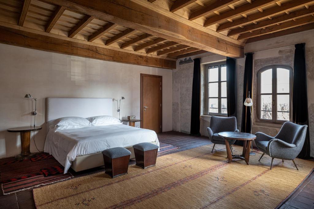 1 Schlafzimmer mit einem großen Bett und 2 Stühlen in der Unterkunft Casa del Pingone in Turin