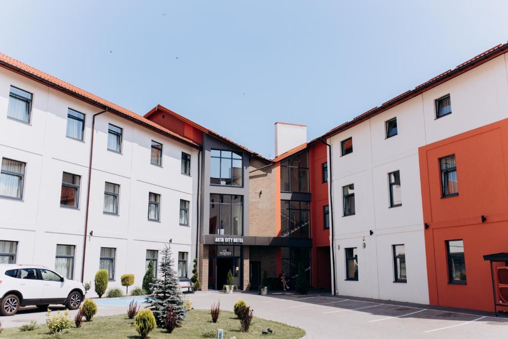 szereg budynków z samochodem zaparkowanym na dziedzińcu w obiekcie Arta City Hotel w mieście Yavoriv