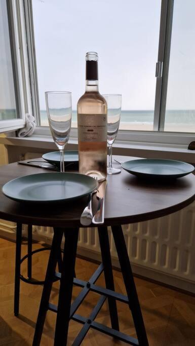 a bottle of wine sitting on a table with glasses at 100 % vue mer, à Berck-sur-Mer in Berck-sur-Mer