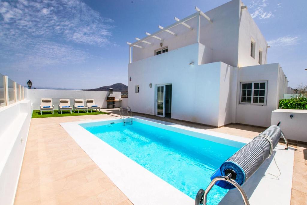 uma villa com piscina em frente a uma casa em 228 - Casa Luca by Villas Now Ltd em Playa Blanca
