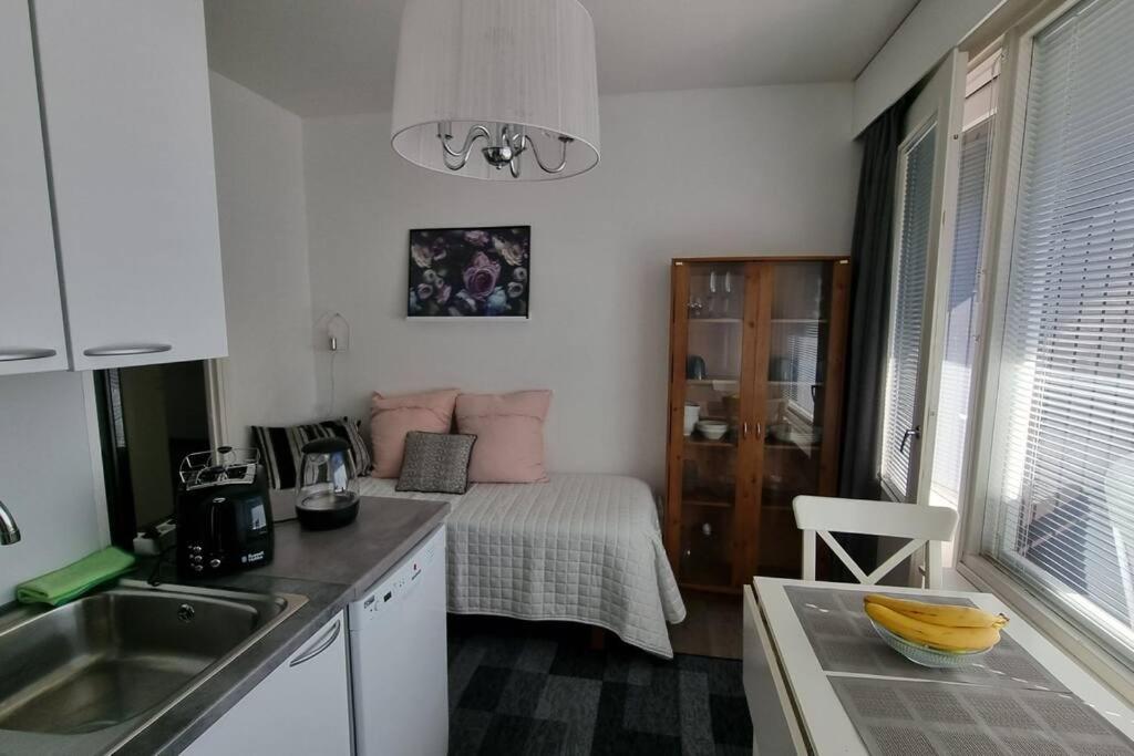 Una pequeña cocina con una cama en una habitación. en Mini Honkamaja, en Kokkola