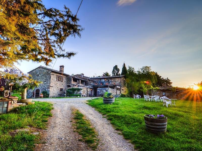 a gravel road in front of a large house at Agriturismo Il Cocco in Montalcino