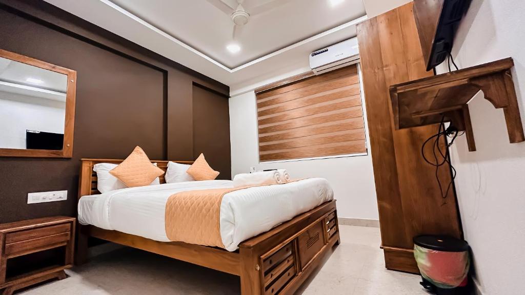 1 dormitorio con 1 cama grande y espejo en EMERALD INN, en Kochi