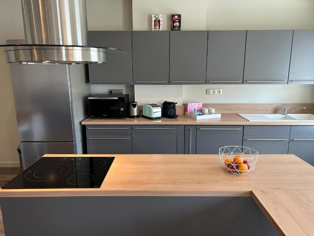 a kitchen with a wooden counter with a bowl of fruit on it at Standing Vieux port 110 m2, Marseille in Marseille